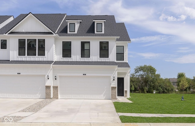 view of front of property featuring driveway, a shingled roof, a front lawn, board and batten siding, and brick siding