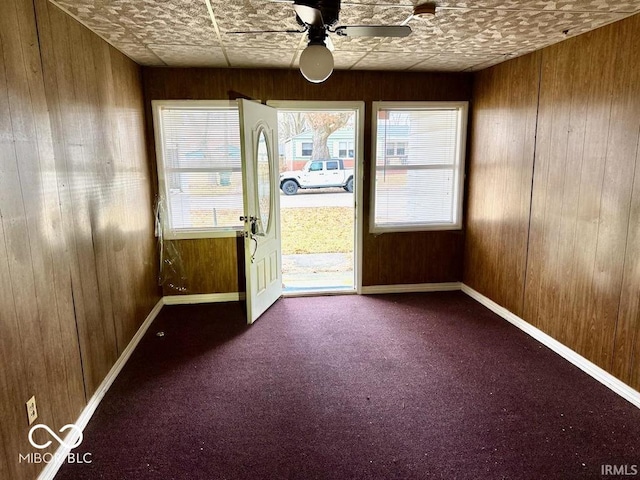 unfurnished sunroom featuring ceiling fan