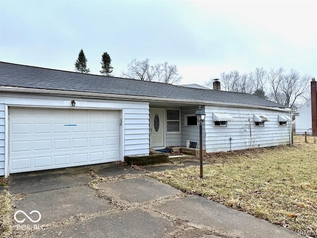 ranch-style house featuring a garage, entry steps, a shingled roof, concrete driveway, and a front lawn