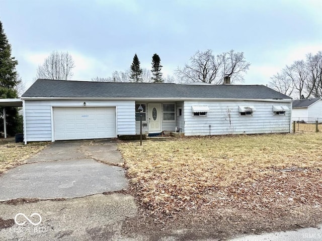 ranch-style house with a front yard, driveway, an attached garage, and fence