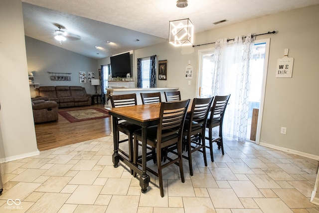 dining area with visible vents, vaulted ceiling, baseboards, and ceiling fan with notable chandelier