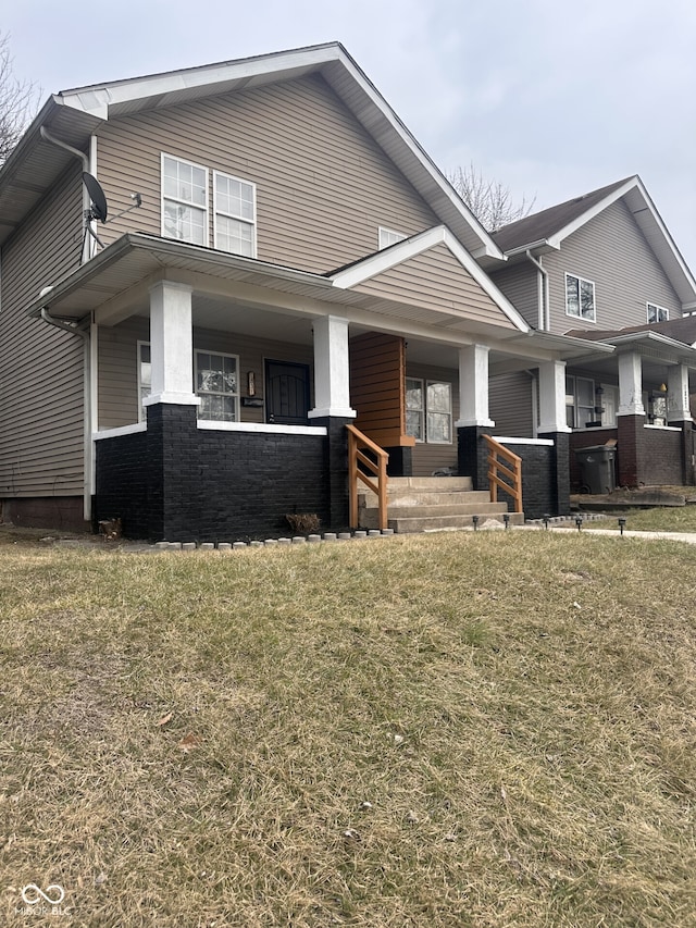 view of front of home featuring covered porch and a front lawn