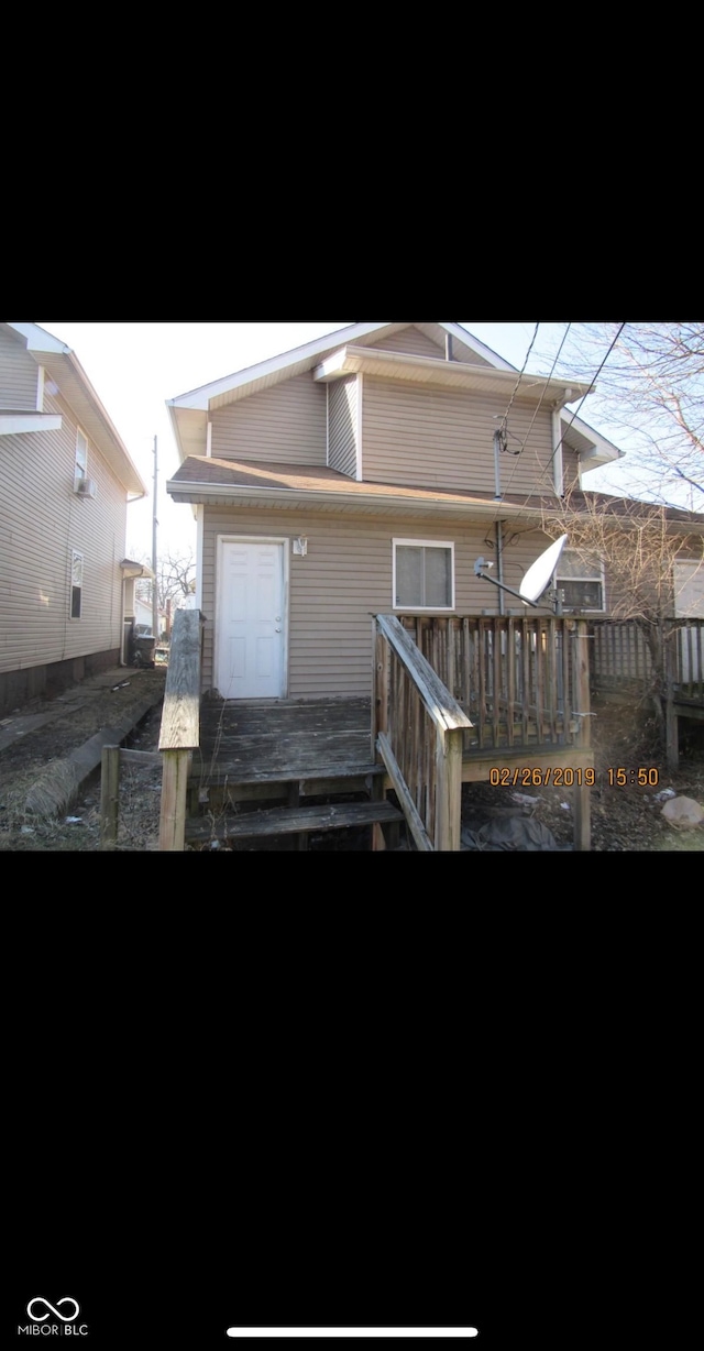 rear view of property featuring a wooden deck