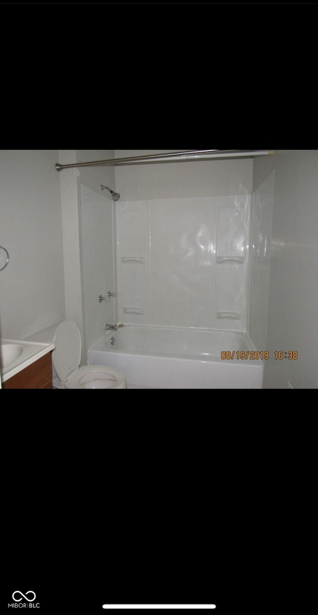 bathroom featuring shower / bath combination and toilet