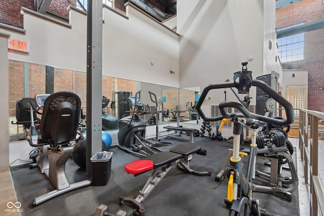 gym with brick wall and a towering ceiling