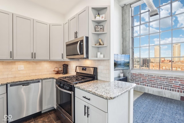 kitchen featuring light stone countertops, open shelves, stainless steel appliances, a view of city, and backsplash