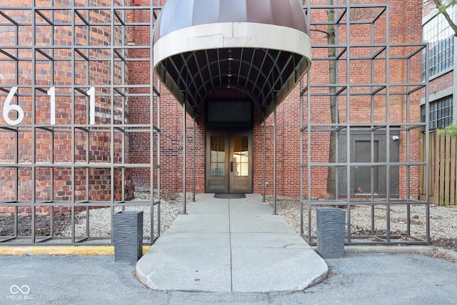 entrance to property featuring french doors and brick siding