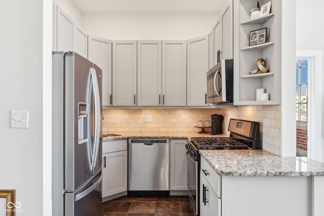 kitchen with open shelves, light stone countertops, tasteful backsplash, and appliances with stainless steel finishes