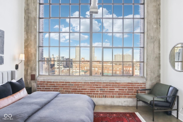 bedroom with a view of city and brick wall