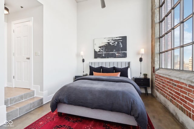 bedroom featuring multiple windows and concrete floors