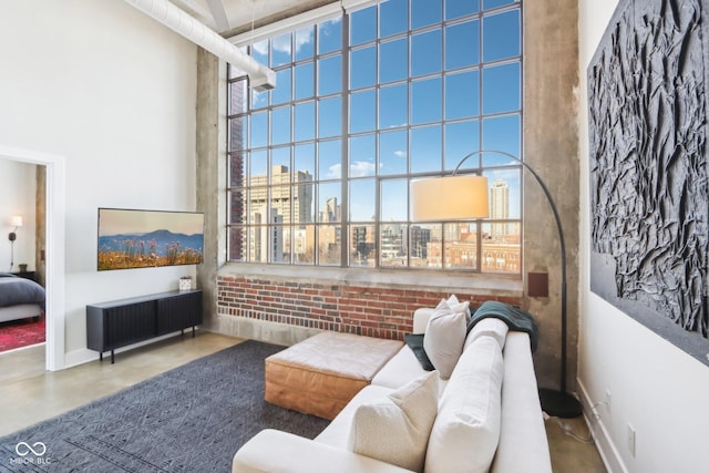 interior space with brick wall, finished concrete flooring, and a towering ceiling