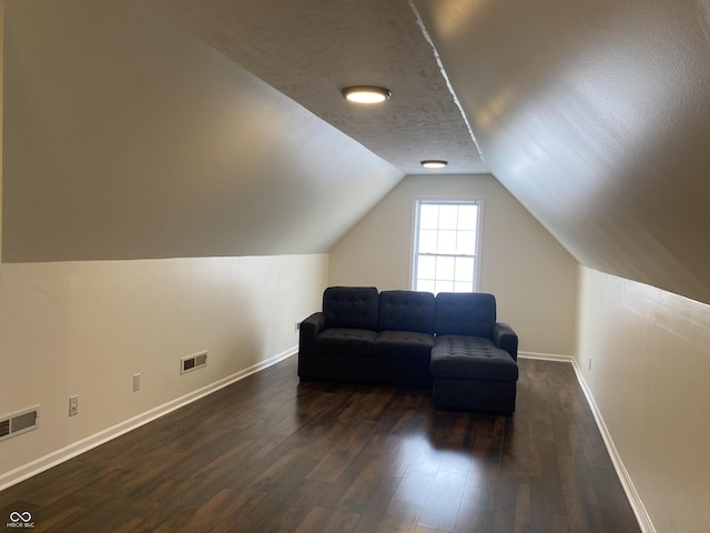 sitting room featuring lofted ceiling, dark wood-style floors, baseboards, and visible vents