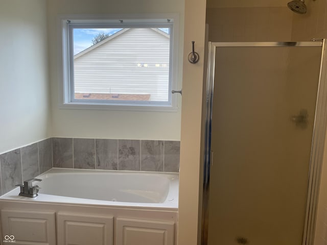 bathroom with a stall shower and a bath