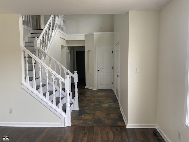 staircase featuring baseboards and wood finished floors