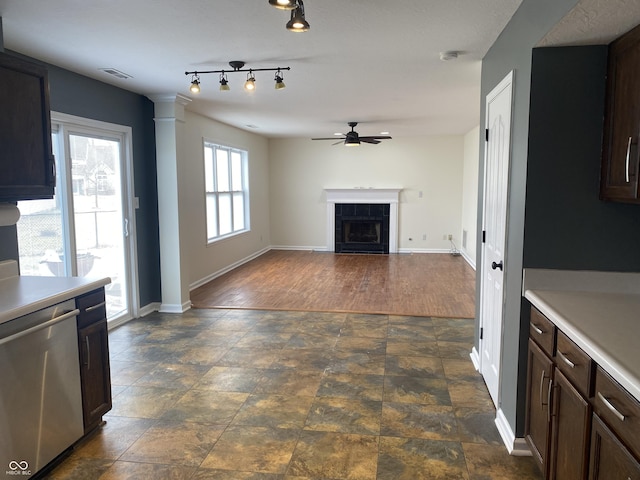 kitchen with visible vents, a tiled fireplace, a ceiling fan, dishwasher, and light countertops