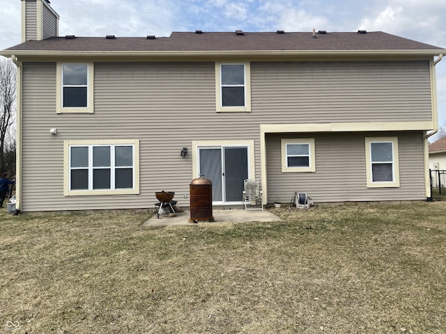 back of property with a patio area, a lawn, and a chimney