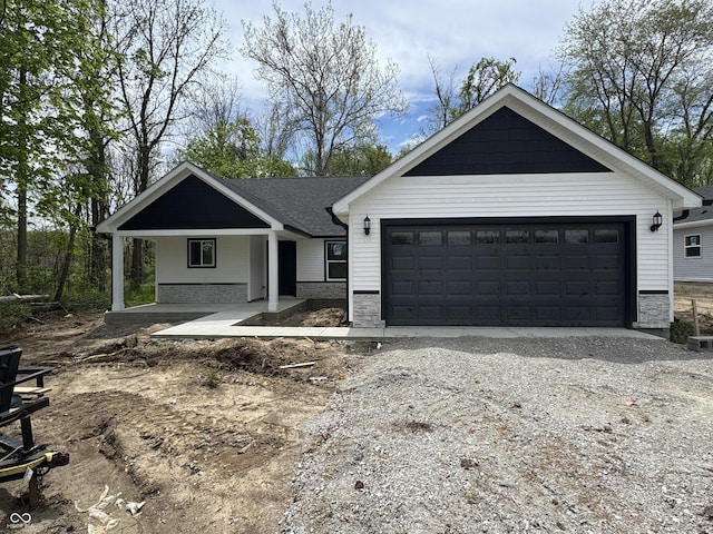 565 Mill Spgs, Coatesville, IN 46121 - view of front of property featuring stone siding, driveway, an attached garage, and a porch