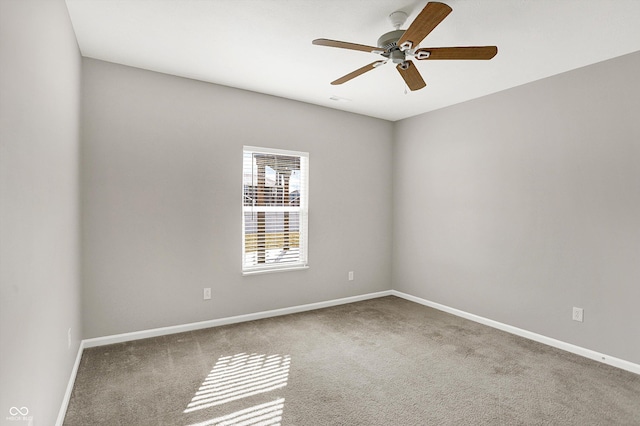 unfurnished room with a ceiling fan, carpet flooring, and baseboards