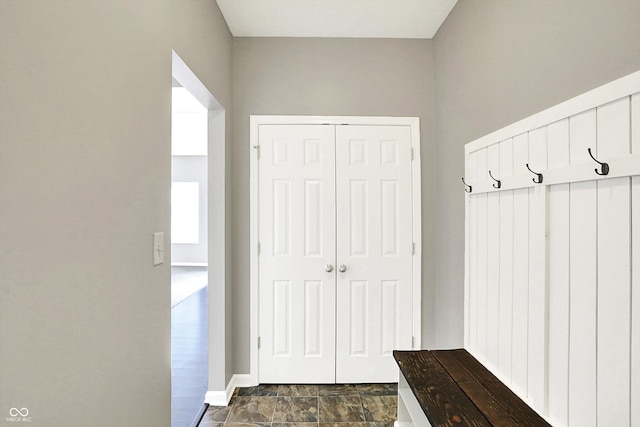 mudroom with stone finish flooring and baseboards