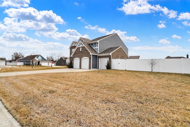 view of front facade with a garage, brick siding, fence, driveway, and a front lawn