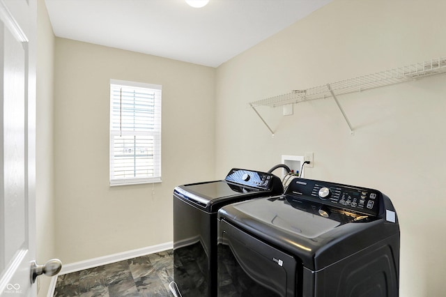 washroom featuring laundry area, washing machine and clothes dryer, and baseboards