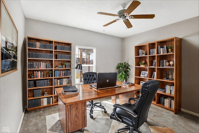 office area with carpet, baseboards, and a ceiling fan