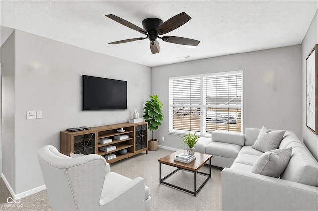 living room with a ceiling fan, light colored carpet, visible vents, and baseboards