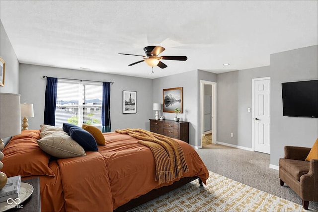 bedroom with ceiling fan, baseboards, and carpet flooring