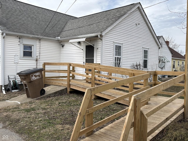 exterior space featuring a deck and roof with shingles