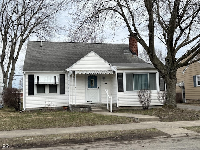 view of front of home with roof with shingles and a chimney