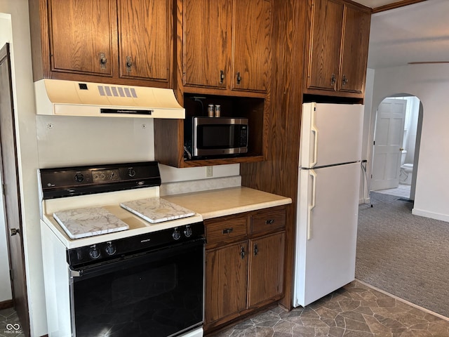 kitchen with black range with electric cooktop, under cabinet range hood, freestanding refrigerator, dark colored carpet, and stainless steel microwave