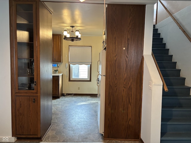 hallway featuring stairway and a chandelier