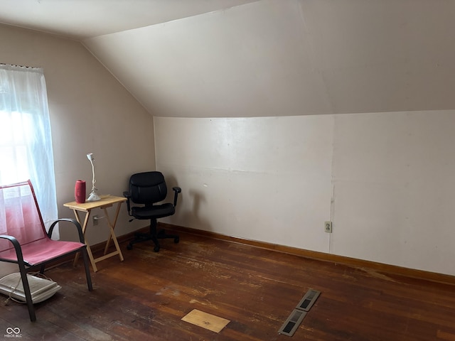 living area with vaulted ceiling, hardwood / wood-style floors, visible vents, and baseboards