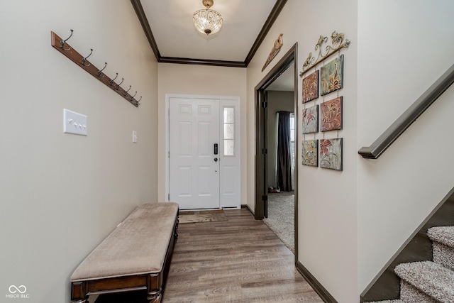 doorway with stairs, baseboards, wood finished floors, and crown molding