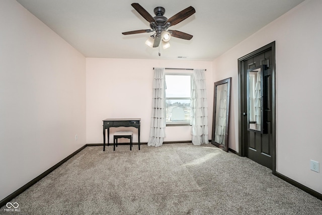 carpeted spare room featuring visible vents, ceiling fan, and baseboards