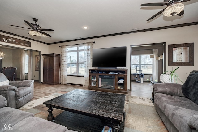 living room with a ceiling fan, recessed lighting, light wood-style flooring, and crown molding