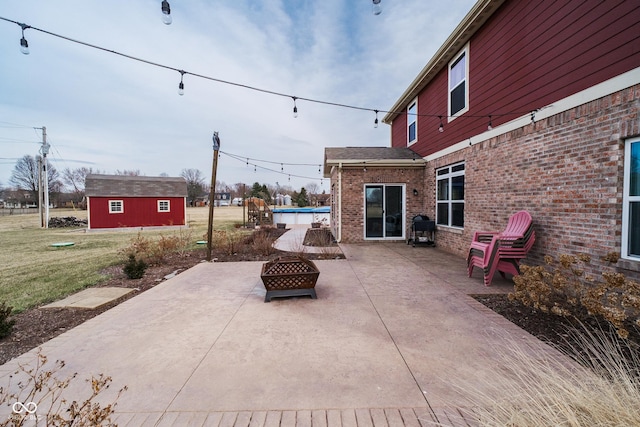 view of patio with an outdoor fire pit and an outbuilding