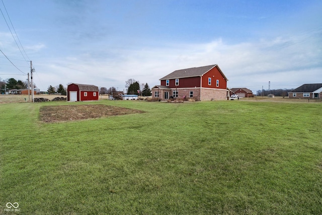 view of yard with an outbuilding, driveway, a detached garage, and a storage shed