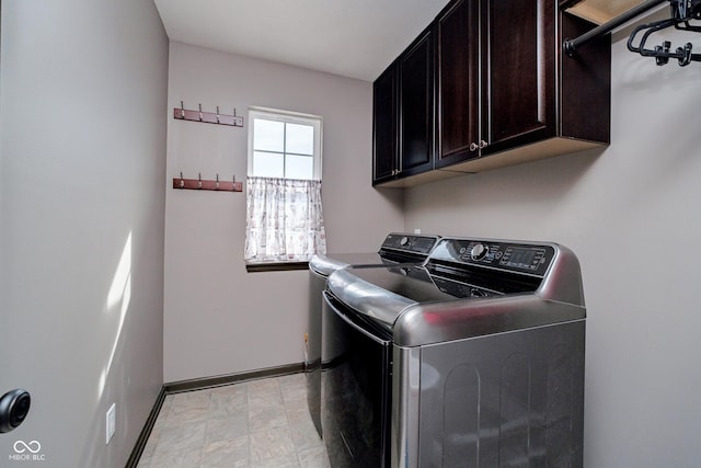 laundry room with washer and clothes dryer, cabinet space, and baseboards