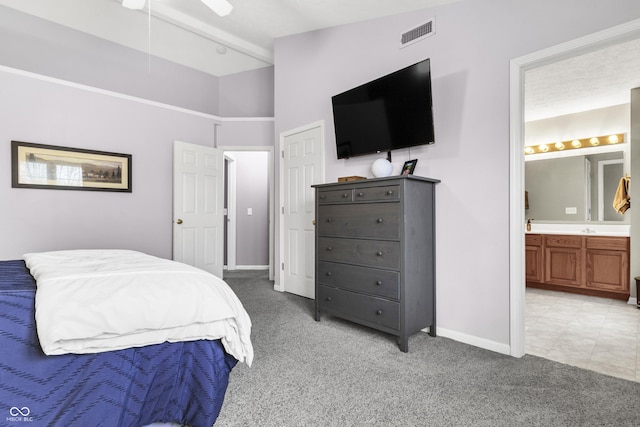 bedroom featuring vaulted ceiling with beams, light colored carpet, visible vents, connected bathroom, and baseboards