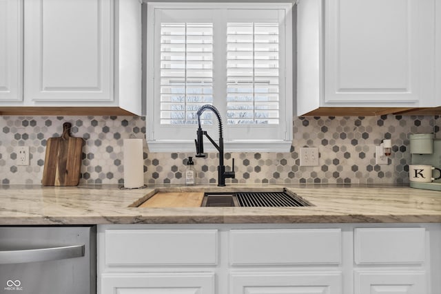 kitchen with a sink, white cabinetry, backsplash, and stainless steel dishwasher