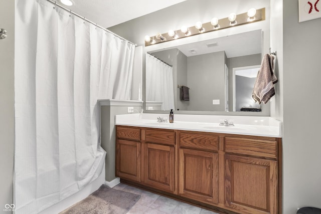 full bath with double vanity, a sink, and tile patterned floors