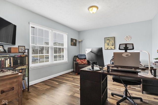 office featuring a textured ceiling, baseboards, and wood finished floors