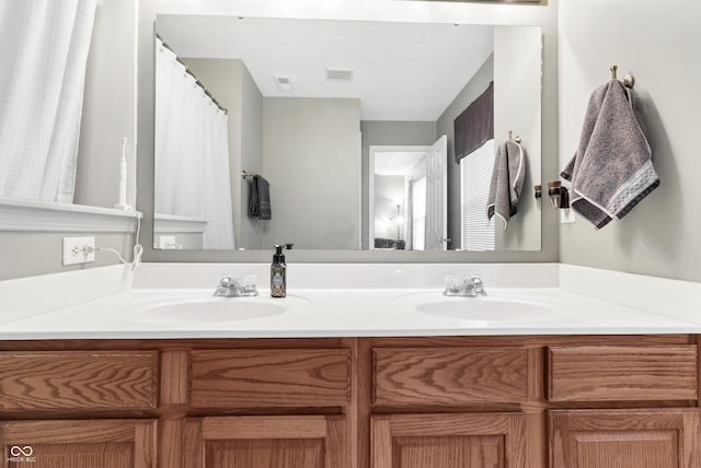 bathroom with double vanity, a sink, and visible vents