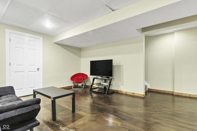 living room with stairway, a paneled ceiling, and baseboards