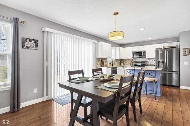 dining room featuring dark wood-type flooring, recessed lighting, and baseboards