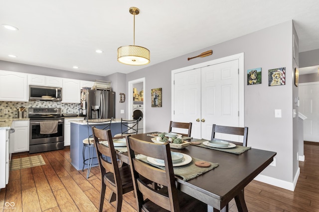 dining room with hardwood / wood-style floors, washer / clothes dryer, recessed lighting, and baseboards