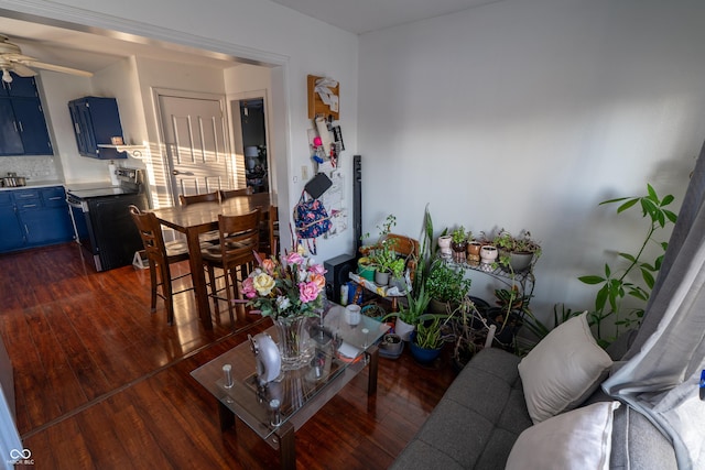 living room featuring a ceiling fan and dark wood-style flooring