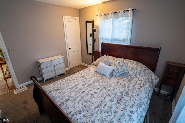 bedroom featuring baseboards, visible vents, and dark colored carpet