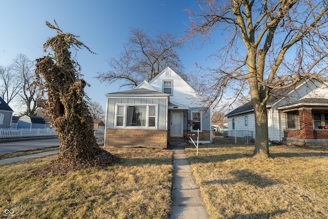 bungalow-style home featuring stone siding, a front lawn, board and batten siding, and fence